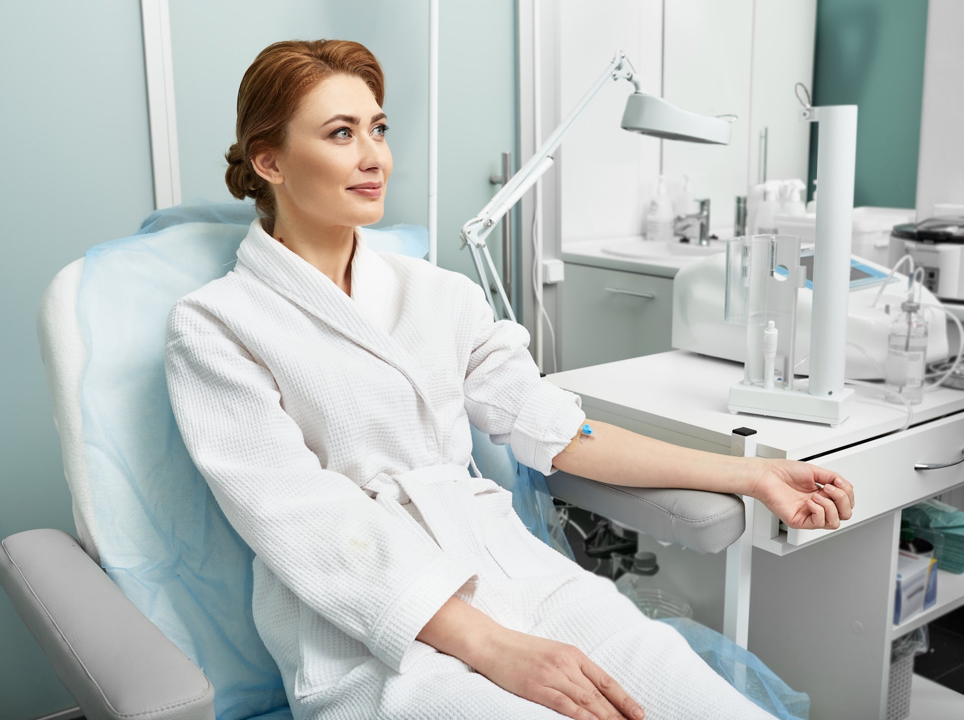 Smiling adult woman before intravenous ozone therapy at a medical clinic